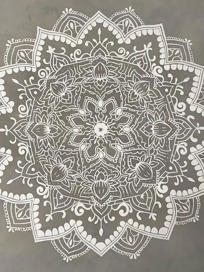 I love the simple elegance of white on grey. This intricate mandala was painted on a textured cement wall, creating a striking and sophisticated focal point.