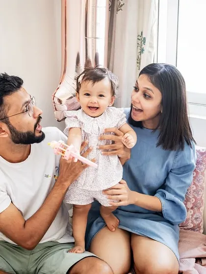A happy family moment on the bed, celebrating their daughter's first birthday. These candid, at-home sessions are all about capturing genuine smiles and interactions.