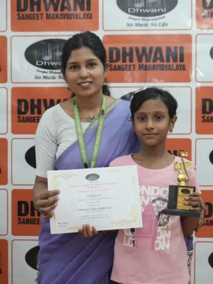 A faculty member presents an award to a young student.