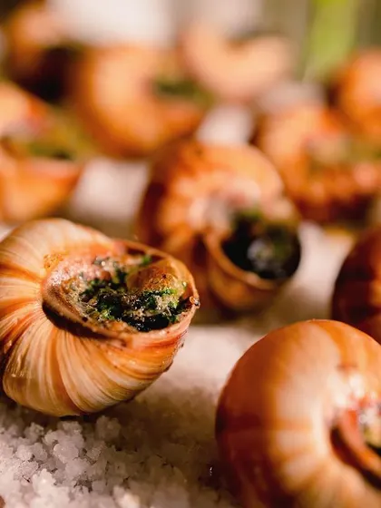 A close-up of classic French escargots on a bed of rock salt.