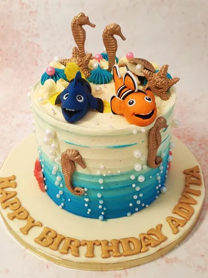 We explore the big blue world with this detailed Nemo and Dory cake. The characters swim amidst golden seahorses, starfish, and delicate pearls on a beautiful ocean-ombre buttercream base, capturing the magic of the underwater world.