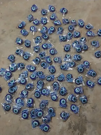 An overhead shot of 100 individually wrapped evil eye keychains, ready for a bulk shipment. This shows my capacity for large-scale orders.