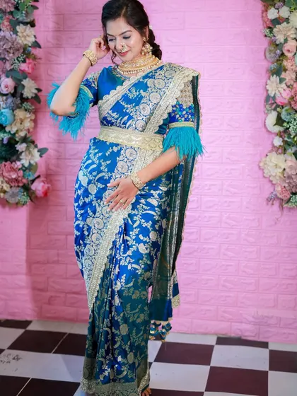 Another angle of the blue Banarasi saree, showing how the drape looks from the side. The feathered sleeves add a fun, modern element.