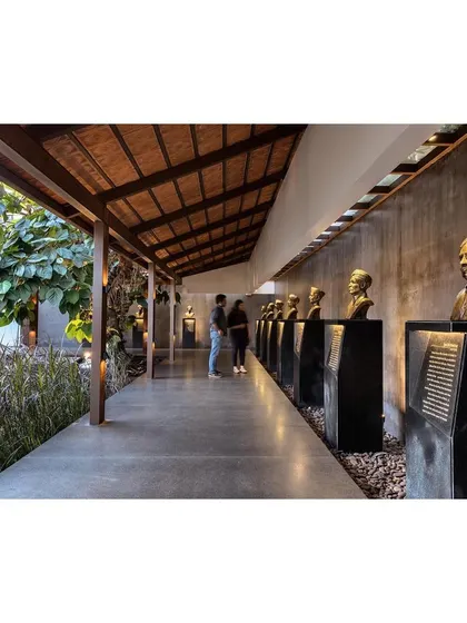 The Rishi Pavilion at the KLE Museum serves as the primary entry path. The landscape becomes performative, guiding visitors along a curated journey past the busts of the institution's founders.