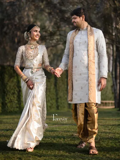A beautiful couple shot capturing the bride's complete look, from her elegant walk to the detailed embroidery on her blouse and her glowing, natural makeup.