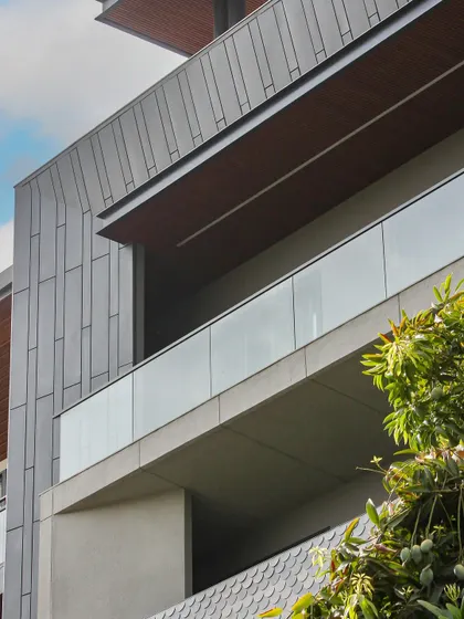 A detail shot of the Akashneem Marg facade, focusing on the clean lines and the interplay of different grey and brown tones. The design is a study in modern, minimal aesthetics.