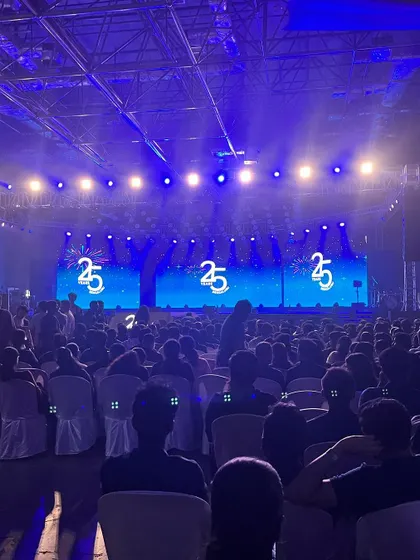 The view from the side of a massive stage for UST's 25th-anniversary celebration. Performing for thousands of employees requires a show that is big, visual, and energetic enough to fill a venue of this scale.