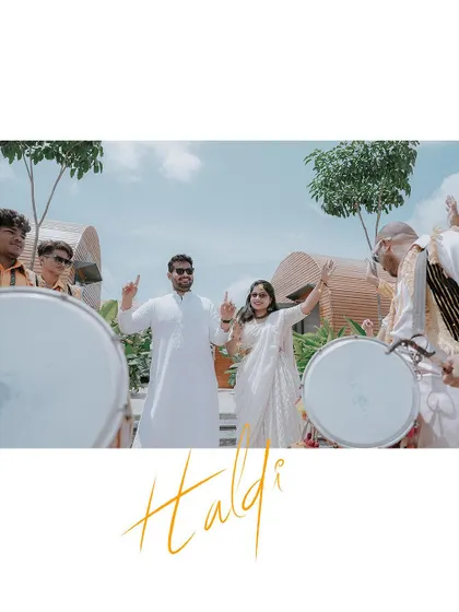 A fun and energetic shot of the couple dancing with dhol players at their Haldi ceremony.