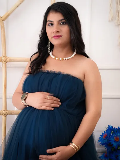A lovely close-up portrait of an expecting mother. Her serene expression and the soft details of her pearl necklace create a classic and timeless maternity photo.