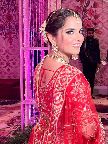 A candid shot of the bride looking back with a joyful smile. Her hair is styled in a beautiful bun with fresh flowers, adding a touch of romance to her look.