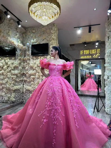 Our model looking radiant in the rose pink ball gown. This shot captures her confident pose and the way the gown's vibrant color and intricate details command attention.