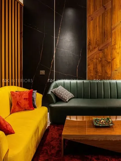 A bold living room design combining a yellow sofa with a dark green one, set against a backdrop of wood and fluted panels.