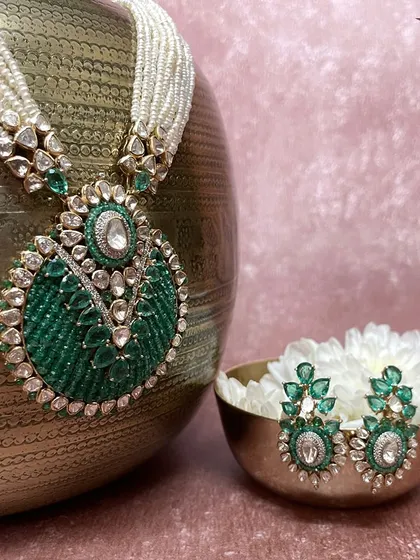 This jewellery is more than just an accessory, it is a symbol of tradition, love, and celebration. The intricate green beadwork and Polki pendant make this a centerpiece for any bridal look.