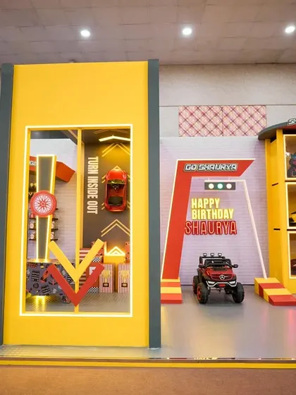 A wide shot of the entire race car themed setup, showing the different zones for photos, games, and activities, all unified by a bold, graphic design.