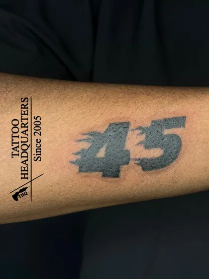 The number "45" tattooed in a bold, stylized font with a motion blur effect, often representing a favorite player or a significant number.