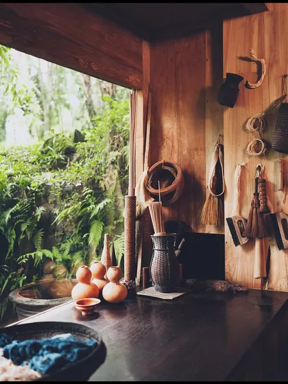 A still-life detail from the 'Pause' campaign set. The curated props, including pottery and natural brushes, help build the world of a creative, mindful retreat.