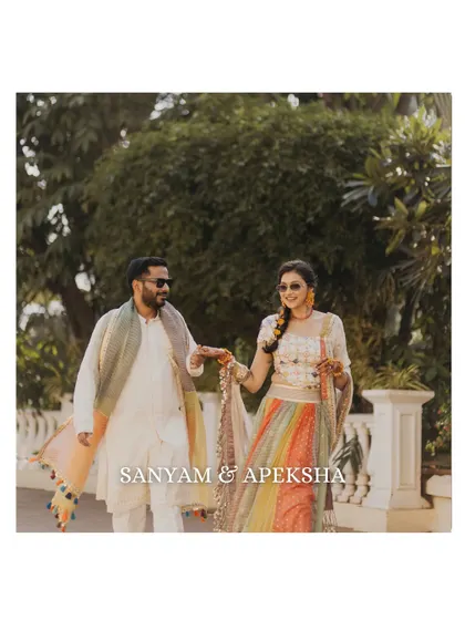 A candid shot of the couple walking together during their Haldi event. Their coordinated outfits and relaxed demeanor make for a lovely, natural portrait.