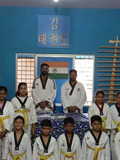 Our yellow belt students pose for a group photo with their instructors. This marks an important milestone in their Taekwondo journey as they move up from the white belt level.