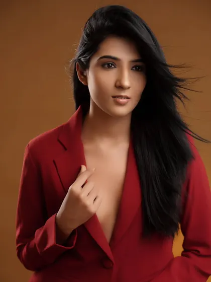 A red power suit against a warm studio backdrop. This image is a great example of a professional yet bold headshot, perfect for actors or corporate clients who want to stand out.