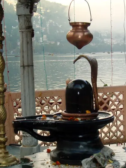 A serene Shiva Lingam established by a lakeside, showing that devotion can be practiced anywhere. I help clients create sacred spaces and find moments for spiritual connection in their daily lives, no matter the setting.