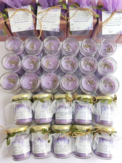 The full display of the purple wedding favors, showing the candles both packaged and ready for packaging.