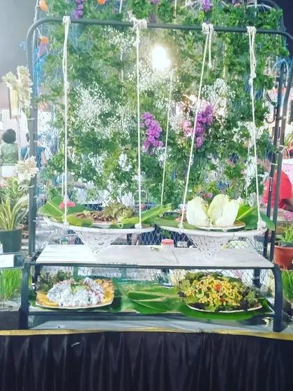 A creative salad bar setup using a swing design with hanging floral arrangements, perfect for garden parties and whimsical wedding themes.