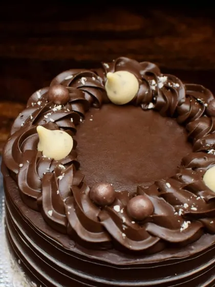 A closer look at the piped chocolate details on this truffle cake. The combination of smooth ganache and decorative piping creates a beautiful texture that's almost too pretty to eat.