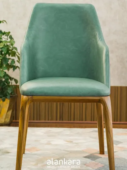 The 'Green Arber' dining chair, upholstered in a beautiful sage green art leather. This adds a subtle touch of color while maintaining a sophisticated and modern feel.