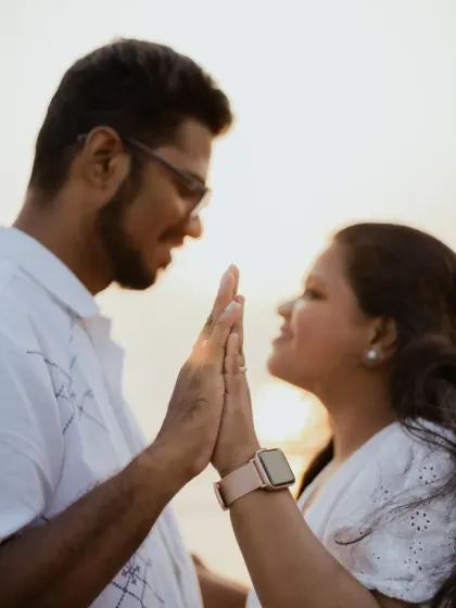 A close-up of the couple's hands coming together, a simple yet powerful gesture of unity and connection.