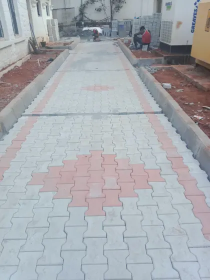 A newly installed walkway using interlocking paver blocks in a two-tone diamond pattern. This type of paving is durable and suitable for high-traffic areas in commercial or residential properties.