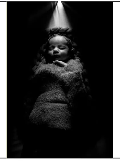 This is an example of my artistic newborn photography. Using dramatic lighting and a soft wrap, I create powerful, fine art portraits that highlight the serene beauty of your sleeping baby.