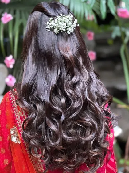 Soft, romantic waves are always a beautiful choice. For Aishwarya's Satsang, we created a simple half-up style with fresh baby's breath for a touch of natural elegance.