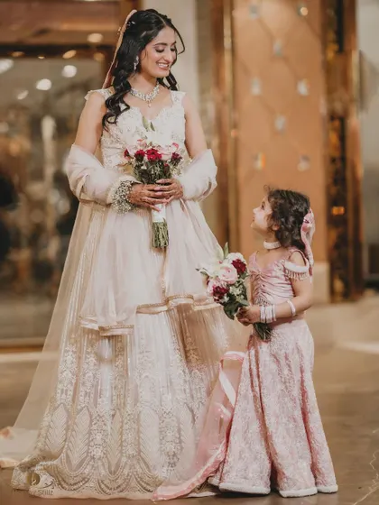 A heartwarming moment between the bride and a little flower girl, who is looking up at her with admiration. This candid shot is incredibly sweet and tells a story.