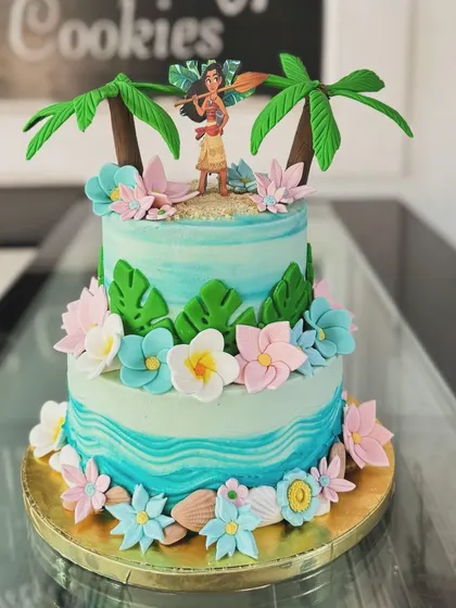 A beautiful two-tiered Moana cake that captures the spirit of the ocean. The design includes tropical flowers, waves, and a fondant Moana figure, perfect for a themed party.