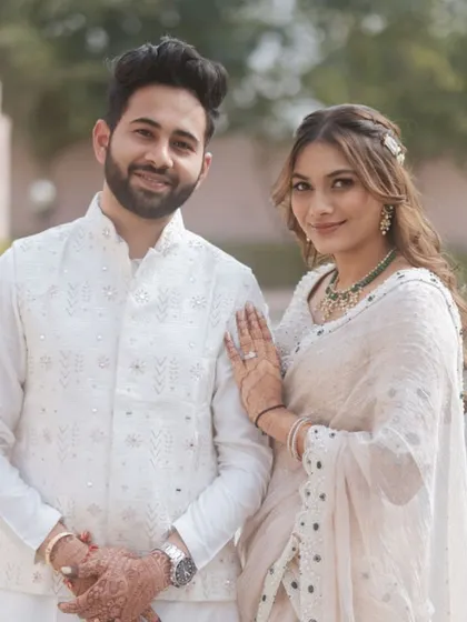 The happy couple posing for a portrait. They both look stunning in their coordinated white outfits.