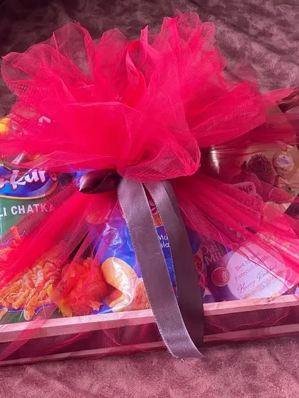 The snack-filled Rakhi hamper wrapped in bright pink tulle, making for a very festive and eye-catching presentation.