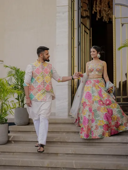 The couple makes a grand entrance at their Haldi ceremony, hand in hand, their colorful outfits perfectly matching the festive theme.