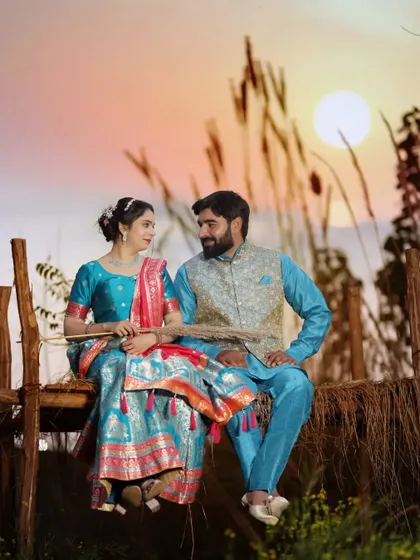 A beautiful sunset shot of a couple in traditional Indian attire. The vibrant colors of their outfits look stunning against the warm, golden light.