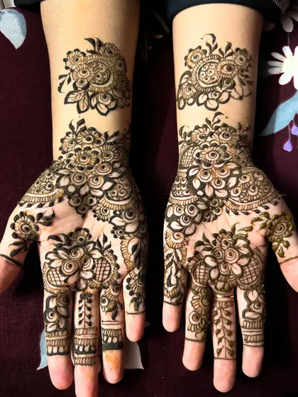 Intricate floral patterns that adorn the hands beautifully. This design features clusters of flowers on the palm and wrist, connected by delicate vines that trail up the fingers.