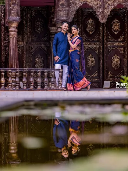 A creative reflection shot of a couple in traditional attire. The perfect symmetry and the rich colors make this a standout, artistic pre-wedding photo.