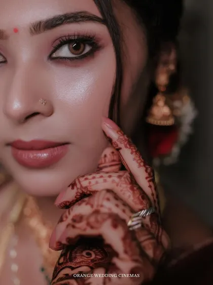 A stunning close-up of the bride's face, highlighting her expressive eyes and intricate henna.