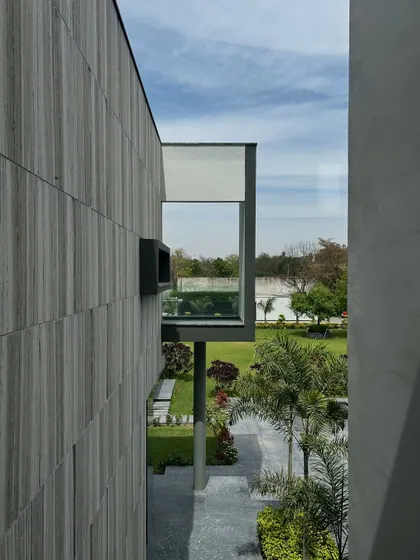 A slit window at the Rosewood residence frames a specific, curated view of the garden and an adjacent balcony. These carefully composed openings are designed to create architectural moments, turning parts of the landscape into living art.