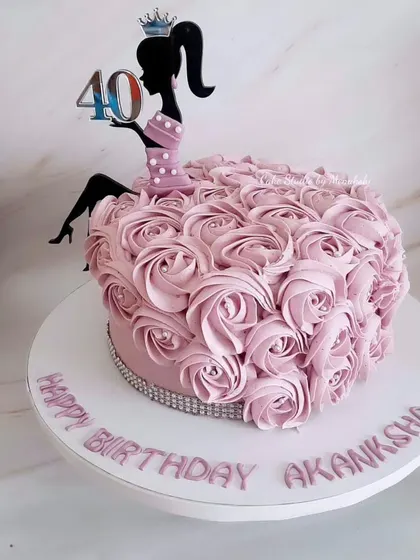 A cake fit for a queen on her 40th birthday. This design features a dress made of hand-piped buttercream rosettes and a silhouette topper, creating a truly special celebration cake.