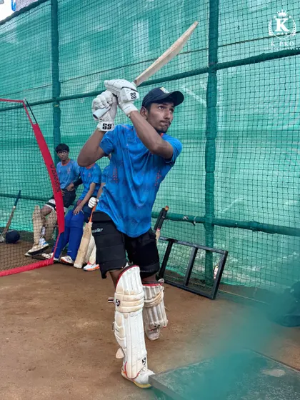 A batsman in the middle of a powerful shot during an outdoor net session, demonstrating strong technique and intent.