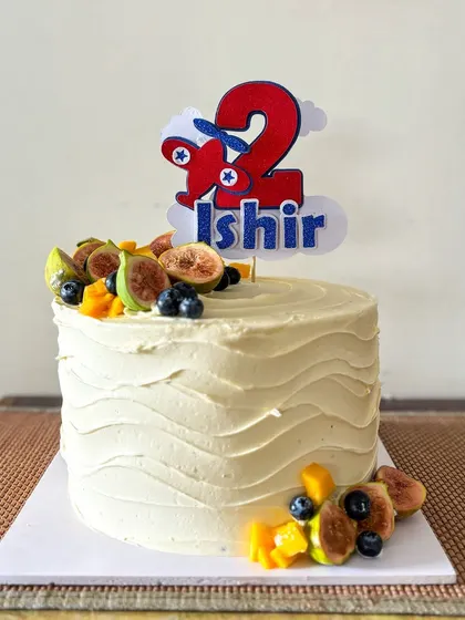 Sometimes simple is best. This is a delicious fruit cake with a textured buttercream finish, decorated with fresh figs, blueberries, and mango. The custom airplane topper makes it perfect for a 2nd birthday.
