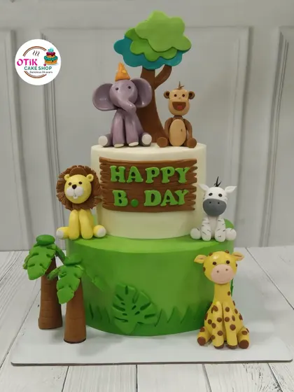 A two-tiered jungle adventure cake perfect for a young explorer's birthday. We decorated it with friendly, handcrafted fondant animals like a lion, elephant, and giraffe to create a fun and delicious centerpiece.