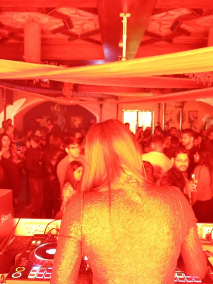A view from behind the console at Romeo Lane, looking out at a sea of people under red lights. This is my perspective of a party in full swing.