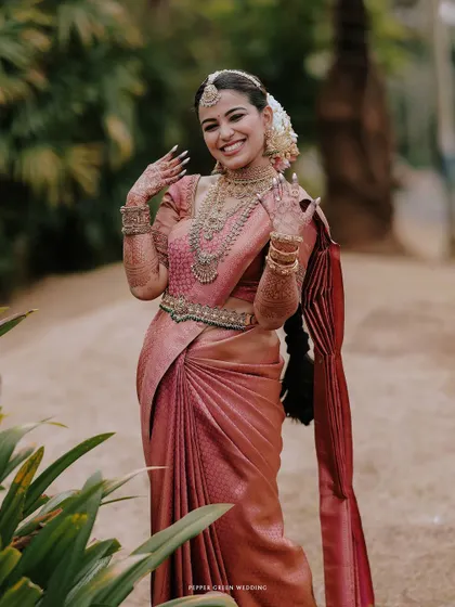 A joyful portrait of the bride, her hands adorned with henna, her smile bright and happy.