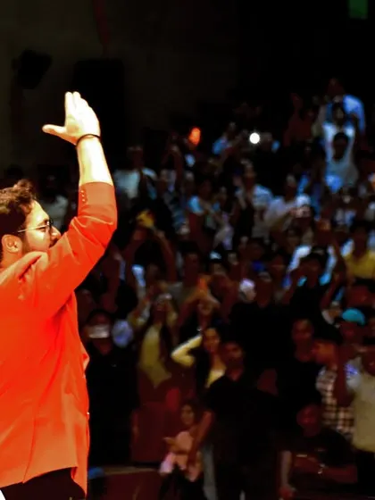 Waving to a massive audience in Patna. Connecting with every section of a large auditorium is a skill I've honed over years of hosting big events.