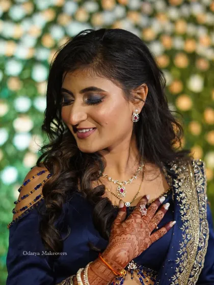 A soft, smiling pose showing off the beautiful blue eyeshadow and flawless skin. This look is perfect for a bride who wants to make a statement at her reception.